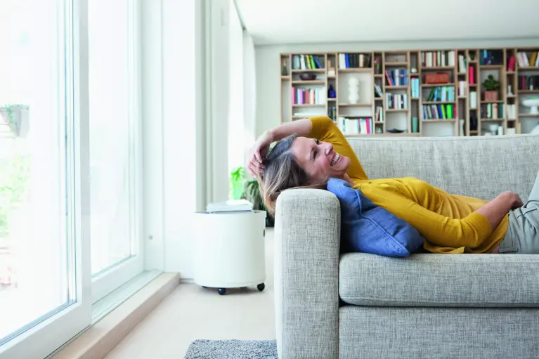 Frau liegt auf Sofa und lächelt