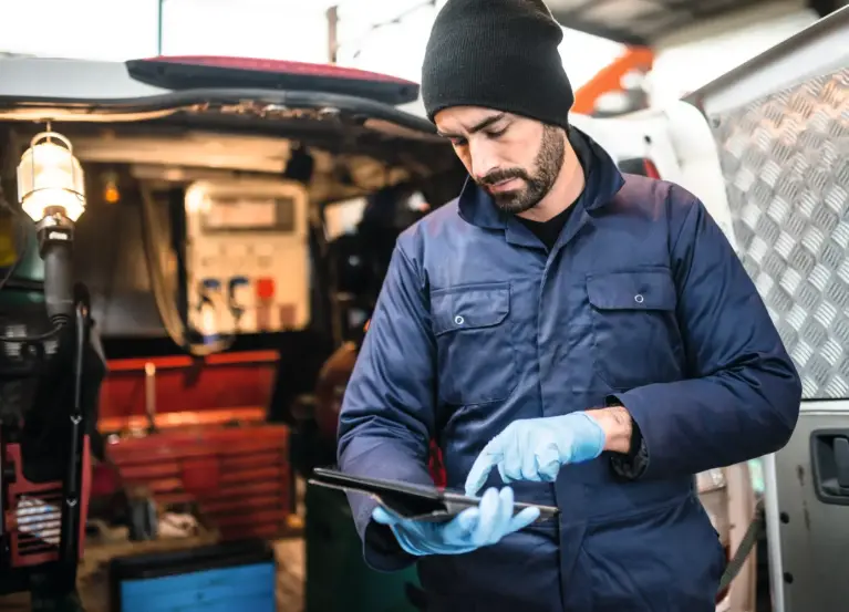 Installateur met blauwe handschoenen raakt tablet aan