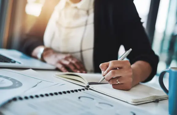 Planificatrice à son bureau, tenant un stylo 