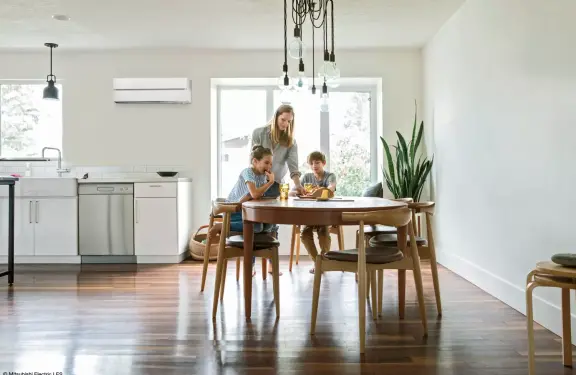 Mère avec sa petite fille et son fils à la table à manger. Une armoire murale blanche est accrochée au mur